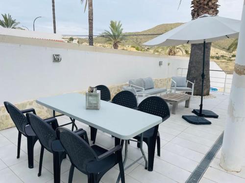 a white table with chairs and an umbrella on a patio at Casa Evie in El Campello