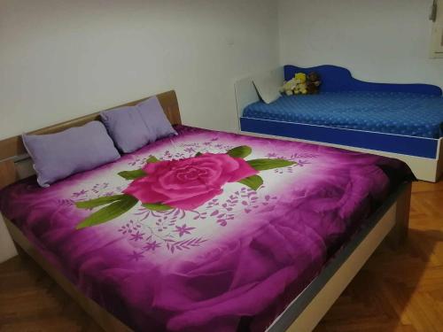 a bedroom with a purple bed with a flower on it at ANAHOME in Gevgelija
