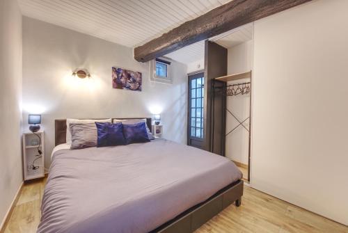 een slaapkamer met een groot bed met blauwe kussens bij Appart cosy Avignon intra-muros - WIFI TV Netflix in Avignon