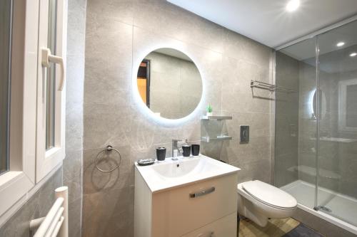 een badkamer met een wastafel, een toilet en een spiegel bij Appart cosy Avignon intra-muros - WIFI TV Netflix in Avignon