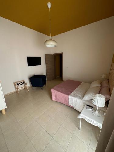 a bedroom with a bed and a chair and a tv at Casa di Marilena in Galatina