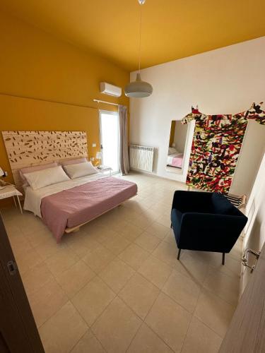 a bedroom with a bed and a black chair at Casa di Marilena in Galatina