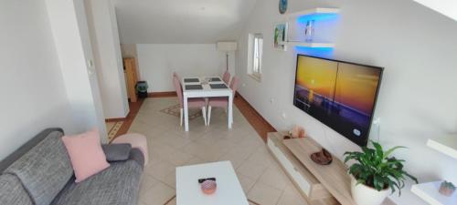 uma sala de estar com um sofá e uma televisão em RITA - Charming 2-Bedroom Apartment with sea view, Slano em Slano