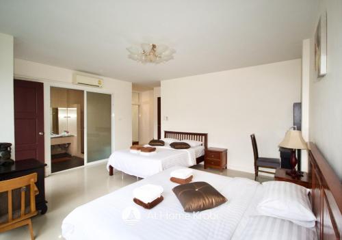 a hotel room with two beds and a table at Ao Nang Mountain View Pool Villa in Ao Nang Beach