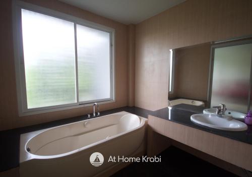 a bathroom with a tub and a sink and a window at Ao Nang Mountain View Pool Villa in Ao Nang Beach