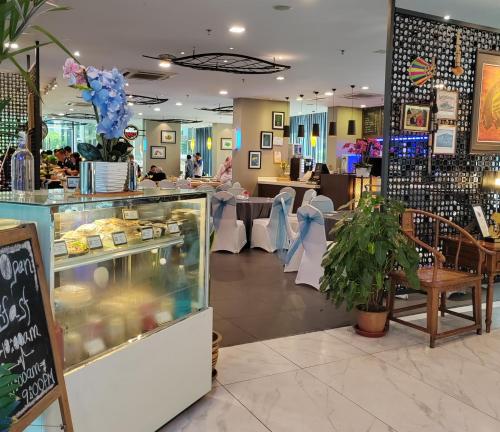 a restaurant with a bakery with a counter and tables at Sky homestay in Kota Kinabalu