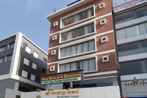 a tall building with a sign in front of it at Sapphero Akshar Inn- Jamnagar in Jamnagar