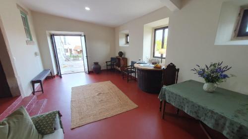 a living room with a table and chairs and a room with a table at Quinta do Passal in Arega