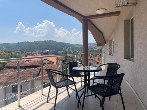 a balcony with a table and chairs on a balcony at Apartmani Vrla in Vladičin Han