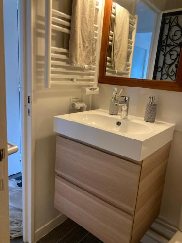 a bathroom with a white sink and a mirror at Charmant Studio avec vue sur le port et falaises in Fécamp