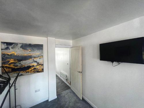 a room with a flat screen tv on a wall at Modern comfortable quiet self contained apartments in Brackley
