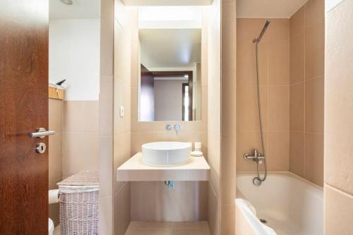 a bathroom with a sink and a mirror and a tub at Herdade dos Salgados Harmonia in Guia