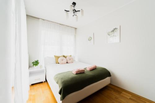 - une chambre dotée d'un lit avec des oreillers roses dans l'établissement Apart City Center - 3 Rooms - Parking Place, à Wrocław