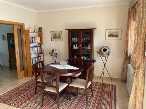 a dining room with a table and chairs and a book shelf at Chez Ilda - Casa da Ilda Alojamento Local in Folhadal