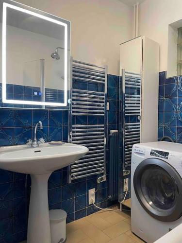 une salle de bain avec une machine à laver et un lavabo dans l'établissement Appartement Victor Hugo 7 couchages, à Biarritz