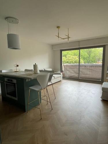 une cuisine avec une table et des chaises dans une pièce dans l'établissement Appartement Victor Hugo 7 couchages, à Biarritz