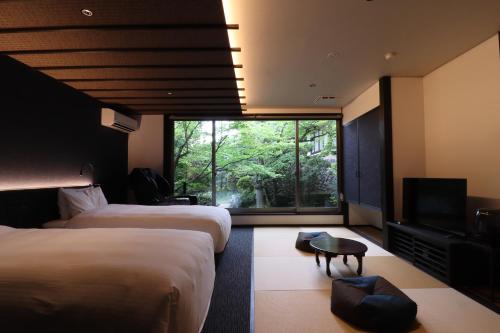 a hotel room with two beds and a television at Yumoto Ueyama Ryokan in Himeji