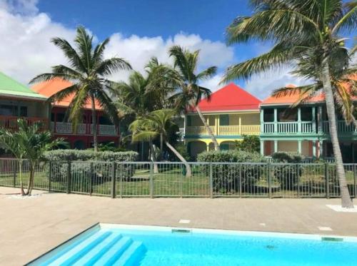 een zwembad voor een huis met palmbomen bij Welcome to Baie Orientale plage - 4 personnes - max 6 personnes in Orient Bay