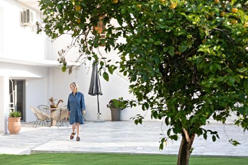 a woman in a blue dress walking through a house at Garden Apartment in Amarynthos II in Amarinthos