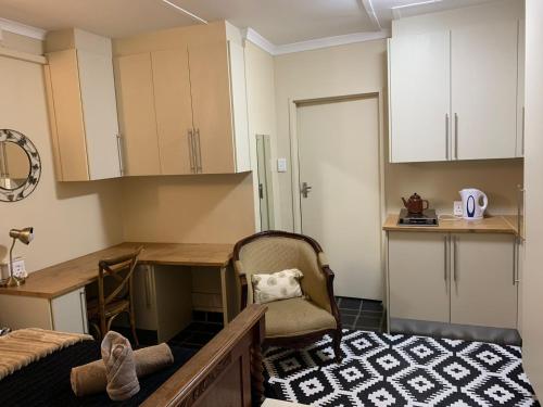 uma cozinha com uma secretária e uma cadeira num quarto em Skinkikofi Guest House em Paarl