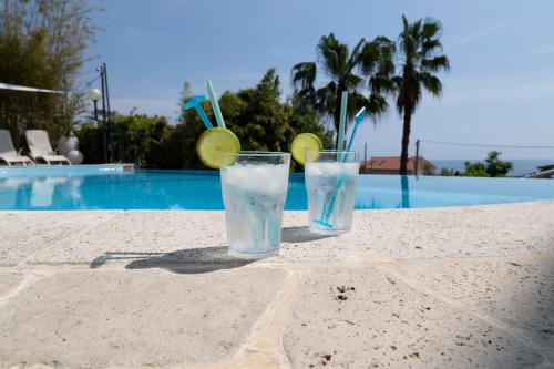 twee glazen water op een tafel bij een zwembad bij Casa Milena elegante dimora con piscina privata in Albissola Marina