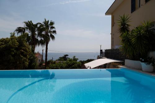 een groot blauw zwembad naast een gebouw bij Casa Milena elegante dimora con piscina privata in Albissola Marina