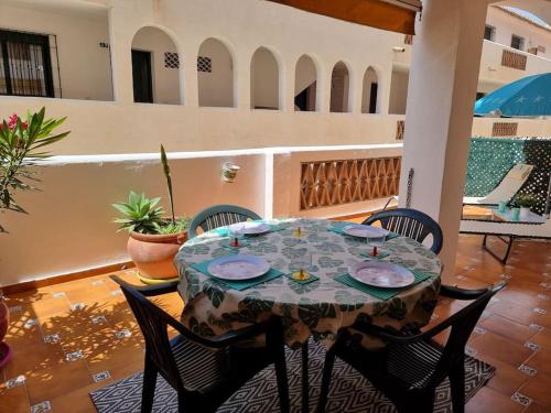 einen Tisch und Stühle auf einer Terrasse mit einem Tisch in der Unterkunft Quilla Apartment in Torrequebrada