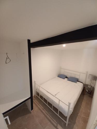 une chambre avec un lit dans une pièce blanche dans l'établissement Gîte Narbonnais avec chambre- proche des plages-Jardin-Terrasse-Parking, à Narbonne