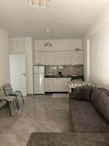 a living room with a couch and a kitchen at Azure beach apartment in Orikum