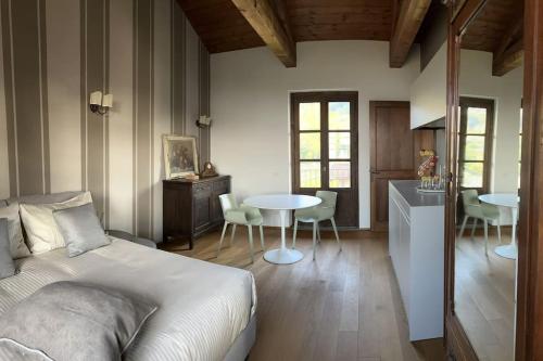 a bedroom with a bed and a table and chairs at Peaceful Luxury Farmhouse - Stunning Alps Views in Saluzzo