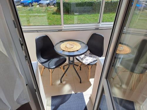 a small table and chairs in a room with a window at Apartmán Lenka in Nová Role