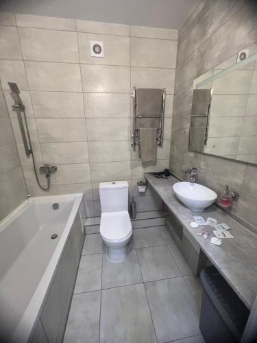 W łazience znajduje się umywalka, toaleta i wanna. w obiekcie Квартира в центре, новострой w mieście Czernihów