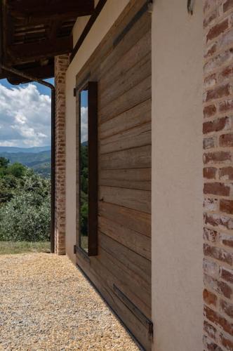 a building with a wooden door and a window at Peaceful Luxury Farmhouse - Stunning Alps Views in Saluzzo