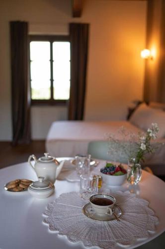 a table with a tea set on top of it at Peaceful Luxury Farmhouse - Stunning Alps Views in Saluzzo