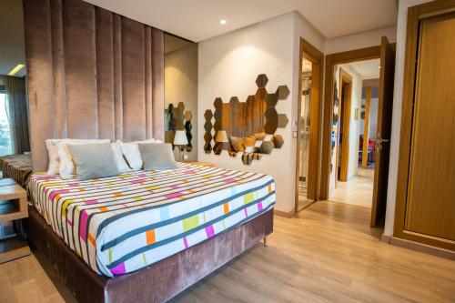 ein Schlafzimmer mit einem großen Bett in einem Zimmer in der Unterkunft Luxury golden view apartment in les terrasses danfa ain diab in Casablanca