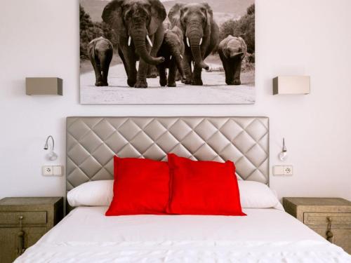 a bedroom with red pillows and a painting of elephants at Villa KM2 lovely villa located just outside of Sa Carroca a 5 minute drive from Playa den Bossa in Sant Josep de Sa Talaia