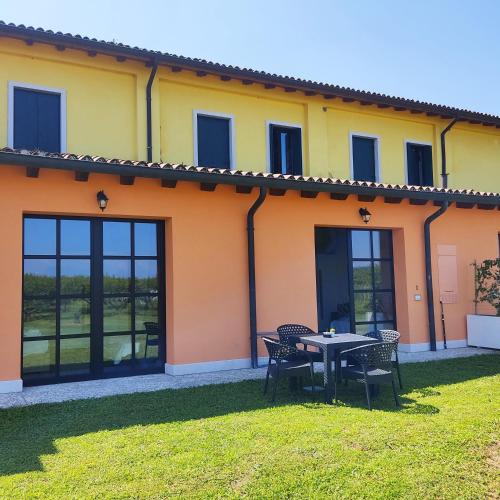 a house with a table and chairs in the yard at La Crosona in Colà di Lazise