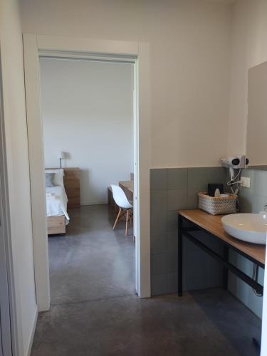 uma casa de banho com uma porta que dá acesso a um quarto com um lavatório em La Crosona em Colà di Lazise