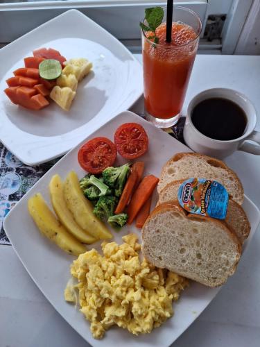un plato de desayuno con huevos, fruta y una bebida en Bingin Inn, en Uluwatu