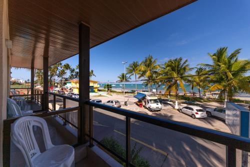 a balcony with a view of the beach and palm trees at Pousada Mariluz in Maragogi