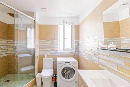 ein Badezimmer mit einer Waschmaschine und einem WC in der Unterkunft Sirona Bay Biarritz - Plages - Casino - WIFI - VOD in Biarritz