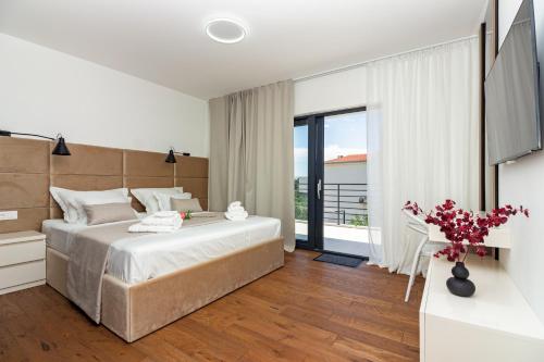 a bedroom with a large bed and a large window at Family House "Villa Gyra" with Private Swimming Pool, Indoor BBQ, Gym and Gaming room! in Podstrana
