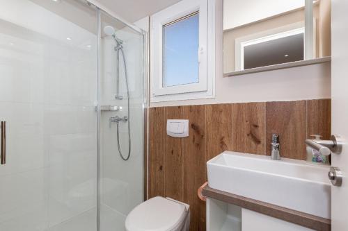 bagno con doccia, lavandino e servizi igienici di Mobile home Kastanjola a Biograd na Moru