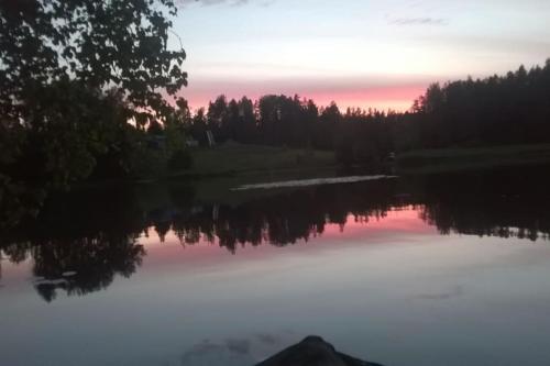 a view of a lake at sunset at Cottage / Mökki, unique summer cottage in Vihti