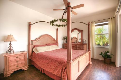 um quarto com uma cama de dossel e uma ventoinha em Villa Magnolia em Cape Coral