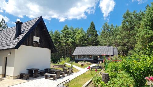 a barn with picnic tables and benches in a garden at House Maka in Rudanovac