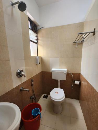 a small bathroom with a toilet and a sink at All Seasons Guest House I Rooms & Dorms in Madgaon