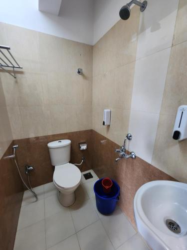 a bathroom with a toilet and a sink at All Seasons Guest House I Rooms & Dorms in Madgaon