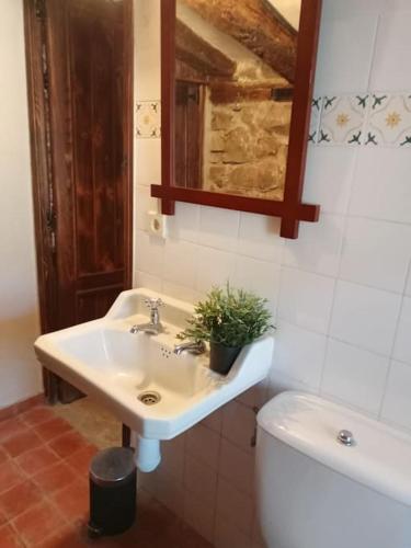 ein Badezimmer mit einem Waschbecken, einem WC und einem Spiegel in der Unterkunft El Refugio de Molinos de Razón. in Molinos de Razón