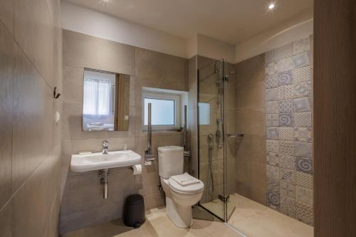 a bathroom with a toilet and a sink and a shower at Satori Boutique Hotel in Acharavi